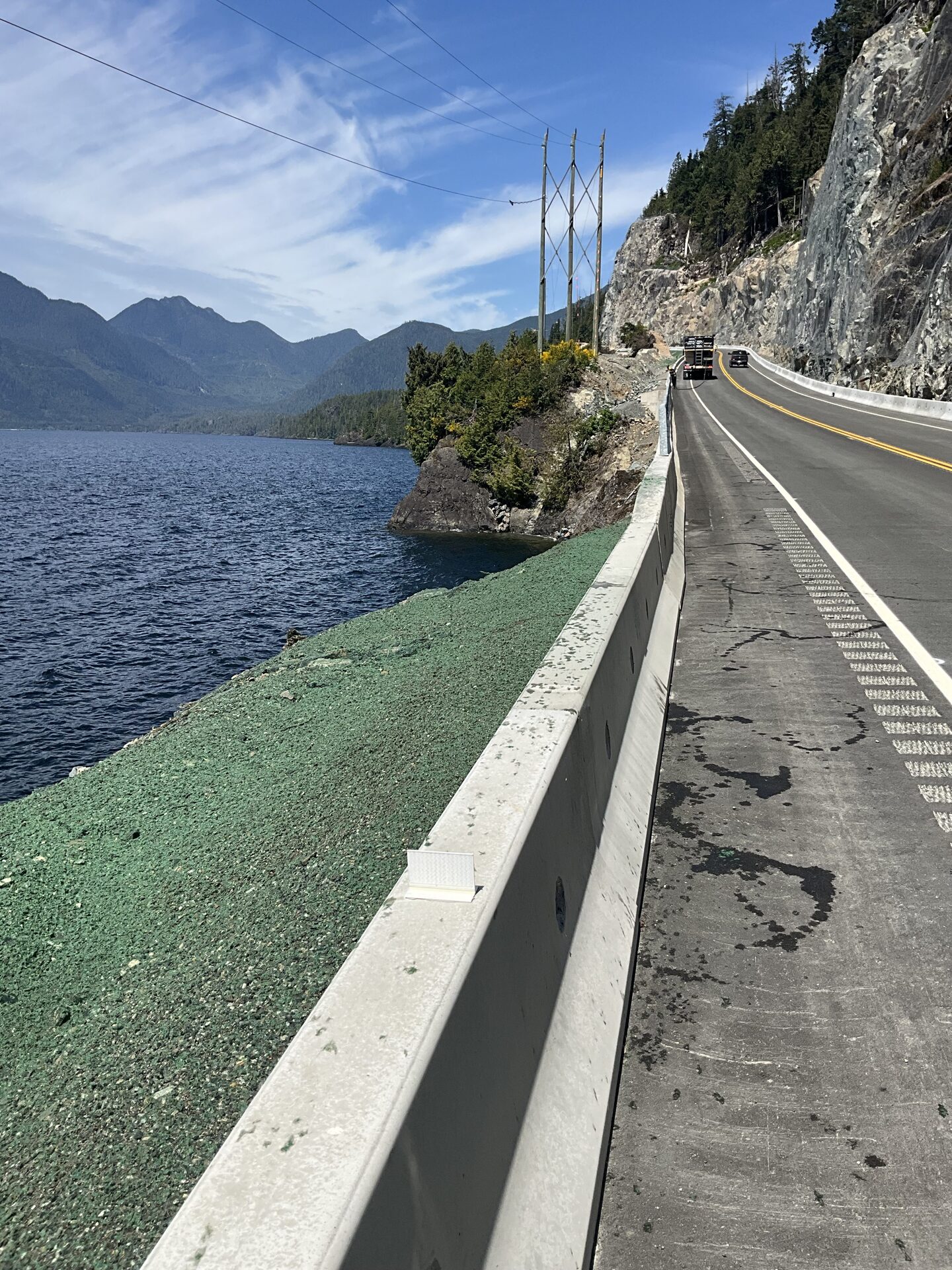 Hydroseeded green strip holding a highway shoulder above the water, BC